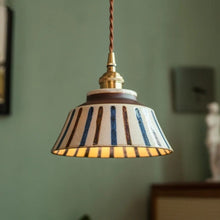 Load image into Gallery viewer, Striped pendant light with a gold fixture against a green wall