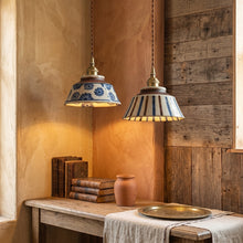 Load image into Gallery viewer, Two pendant lights with decorative shades hanging above a wooden table with books and a vase.