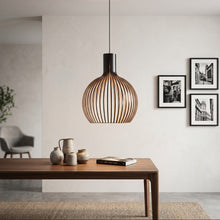 Cargar imagen en el visor de la galería, Modern pendant light hanging above a wooden table with decorative items in a minimalistic room.
