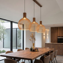 Cargar imagen en el visor de la galería, Modern dining area with wooden table and pendant lights in a well-lit room.

