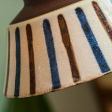 Load image into Gallery viewer, Close-up of a ceramic vase with striped pattern on a blurred background
