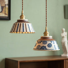 Load image into Gallery viewer, Two ceramic pendant lights with decorative patterns hanging against a green wall.

