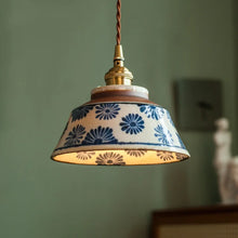 Load image into Gallery viewer, Pendant light with decorative ceramic shade against a green wall
