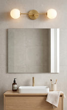 Load image into Gallery viewer, Bathroom setup with a mirror, light fixture, sink, and toiletries.
